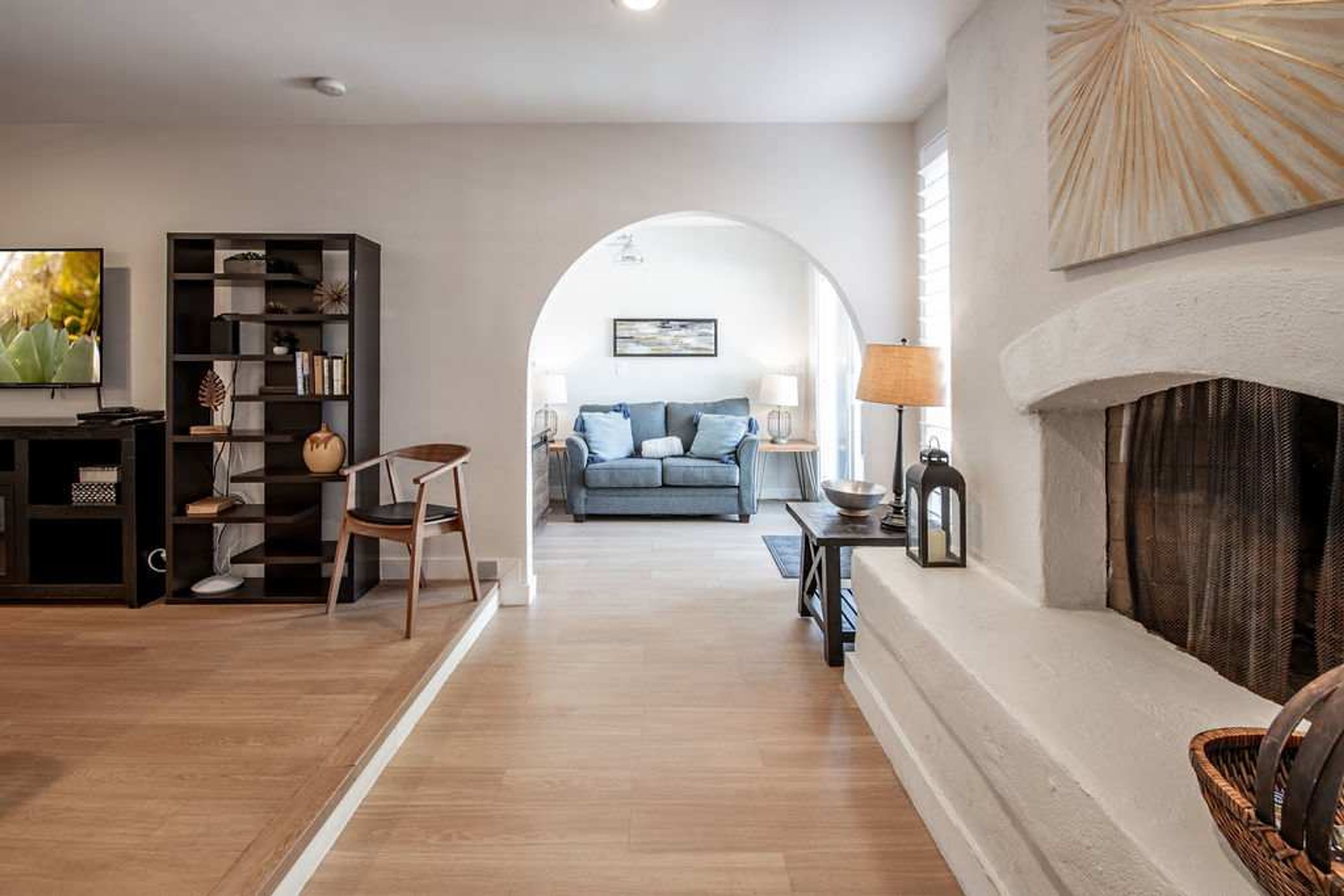 A living room with a fireplace, a sofa, a television, and a bookshelf.