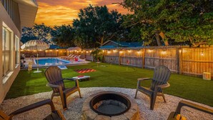 A backyard with a swimming pool, a fire pit, and outdoor seating. - Beach Bliss Movie Theater Putt Putt Pool (Largo)