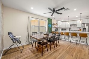 Eine moderne Küche mit Essbereich, Holzboden und Deckenventilator.