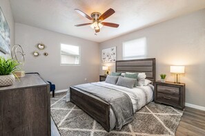 A bedroom with a bed, bedside tables, a ceiling fan, and a window. - Monthly Rental Comfy Beds Great for Remote Work (Clearwater)
