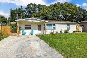 A single-story house with a front porch, two chairs, and a small lawn. - Monthly Rental Comfy Beds Great for Remote Work (Clearwater)
