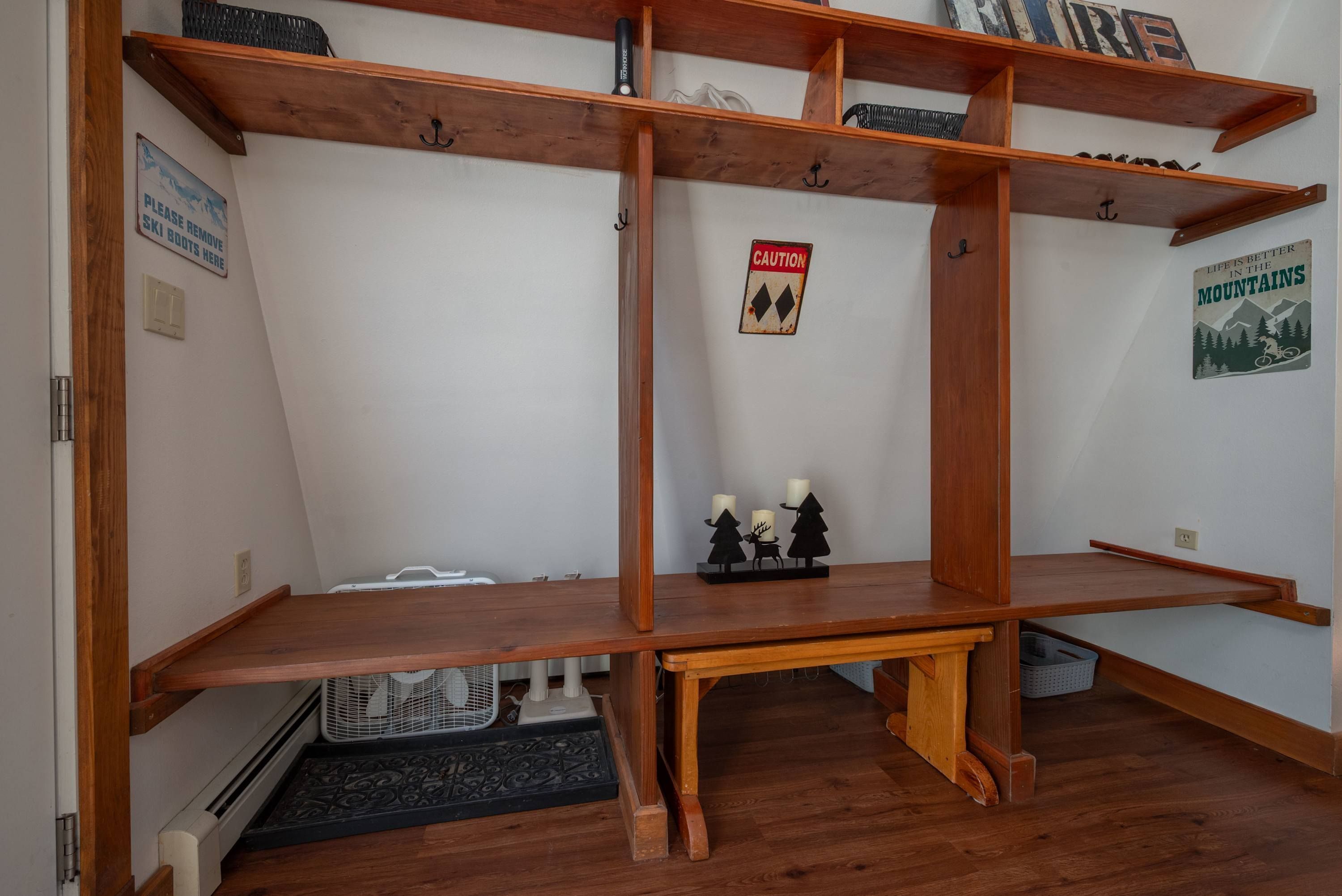 A room with a wooden shelving unit, a caution sign, and a poster on the wall.
