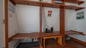 Una habitación con una estantería de madera, un letrero de precaución y un cartel en la pared.