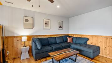 A modern living room with a sectional sofa, a wooden coffee table, and a lamp.