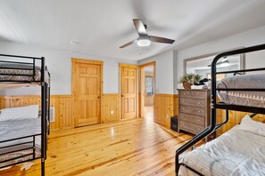 A room with bunk beds, wooden doors, a ceiling fan, and a dresser with a mirror. - 7 min to Hatley Pointe Views Hot Tub 2 Decks (Mars Hill)