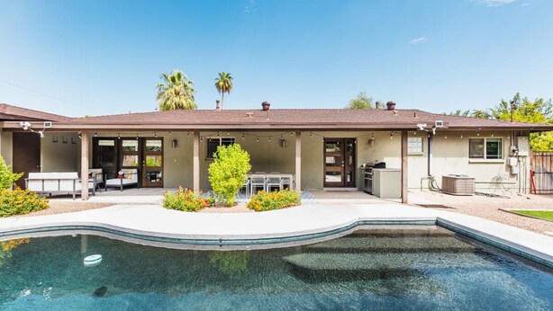 A residential property with a swimming pool, patio seating, and a covered outdoor area. - Right Near Old Town 4BR With Heated Pool (Scottsdale)