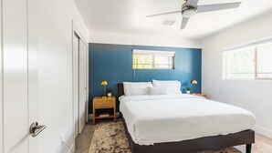 A bedroom with a bed, two bedside tables, a ceiling fan, and a window. - Right Near Old Town 4BR With Heated Pool (Scottsdale)