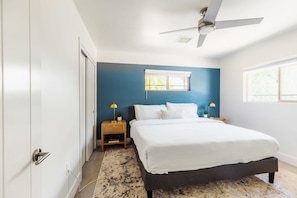 A bedroom with a bed, two bedside tables, a ceiling fan, and a window. - Right Near Old Town 4BR With Heated Pool (Scottsdale)