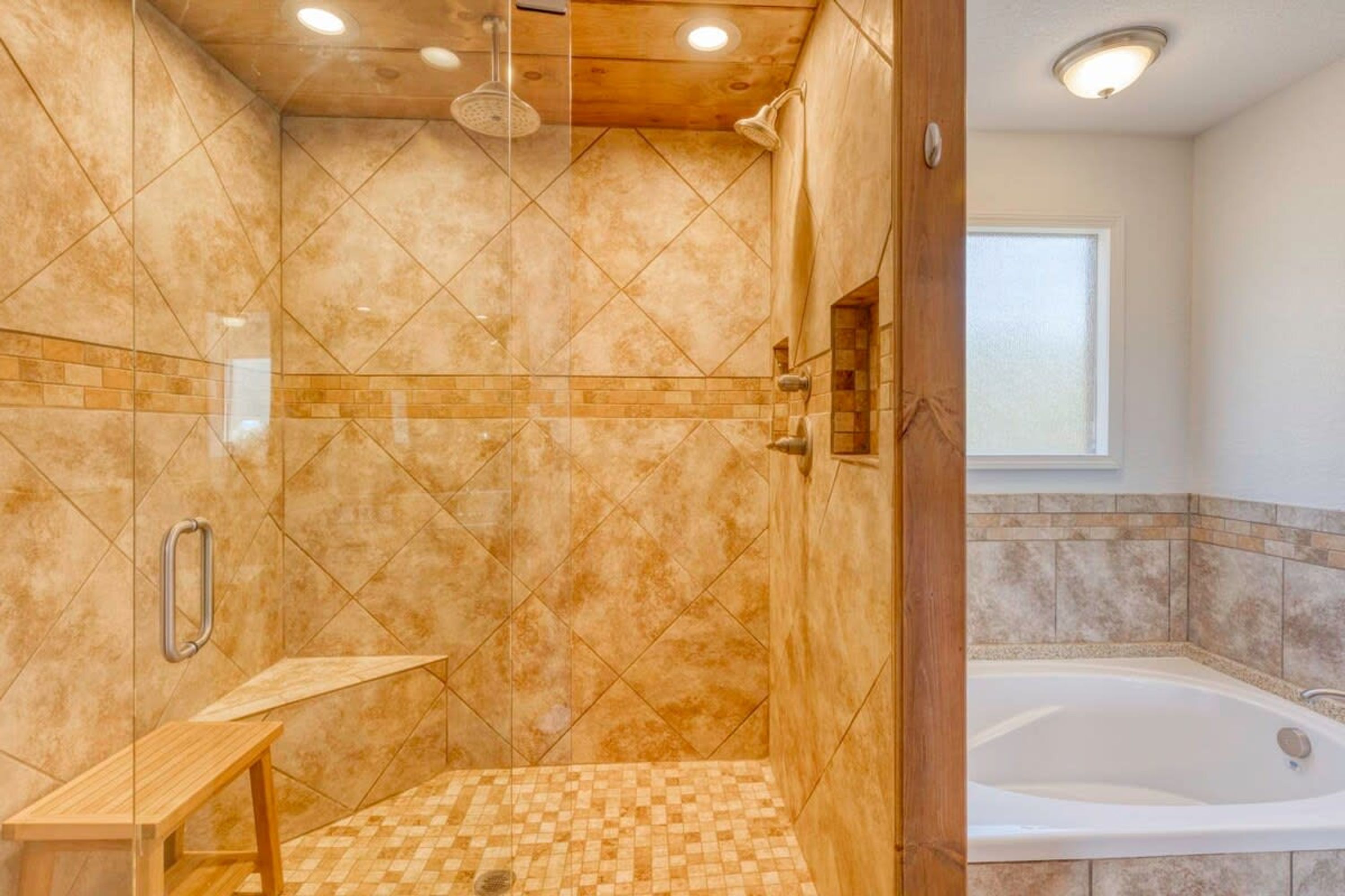 A bathroom with a shower, a bathtub, and a vanity with a mirror.