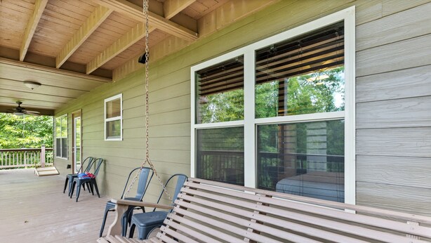 A covered porch with a wooden bench, chairs, and a swing. - Valley Retreat Sleeps 10 Hot Tub Fire Pit (Blue Ridge)