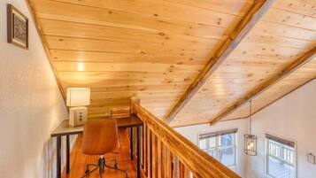 A wooden staircase with a desk and chair, a lamp, and a window with a view.