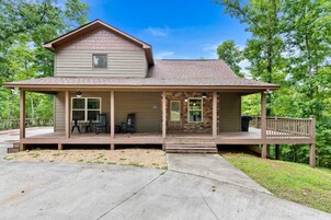 A two-story house with a porch, a covered deck, and a front door.
