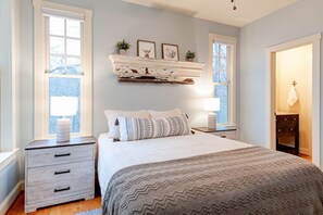 A bedroom with a bed, bedside tables, a dresser, and a window. - Lake Lure Game Room Fire Pit Resort Access (Lake Lure)