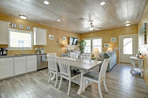 A wooden interior with a dining area, kitchen, and living space. - Toucan Tango- Golf Cart Friendly 3BD Home (Port Aransas)