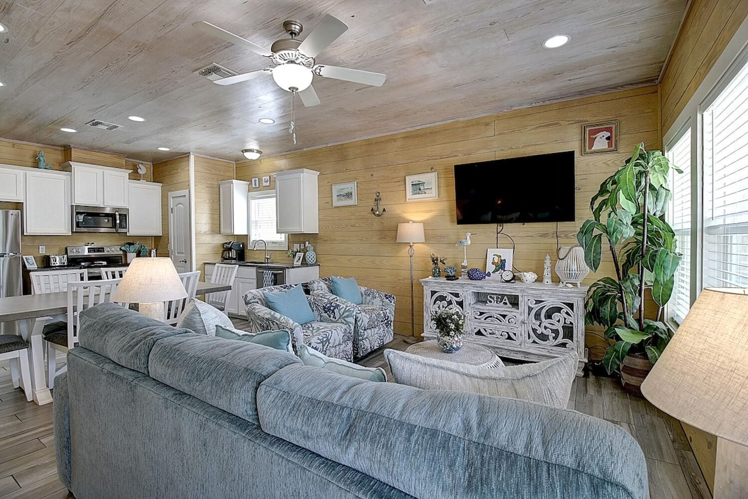 A living room with a sofa, a television, and a dining area with a table and chairs.