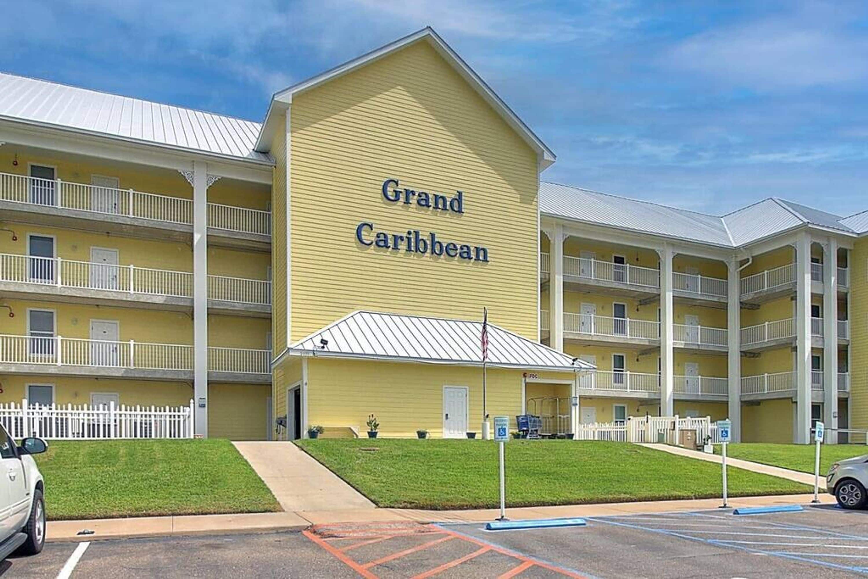 A multi-story hotel named 'Grand Caribbean' with balconies and a parking lot.