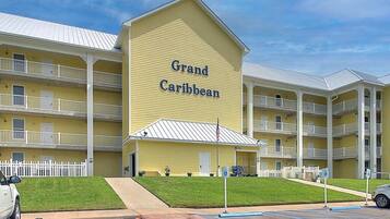 A multi-story hotel named 'Grand Caribbean' with balconies and a parking lot.