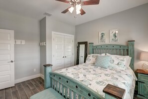 A bedroom with a bed, a ceiling fan, a dresser, and two doors. - Paradise Vibes- Pond Views 2 Balconies (Port Aransas)