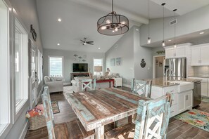 A spacious kitchen with a dining area, a ceiling fan, and a large island. - Paradise Vibes- Pond Views 2 Balconies (Port Aransas)
