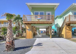 A two-story building with a balcony and a sign indicating a restaurant. - Sweet Home La Cabana Patio BBQ Community Pool (Port Aransas)