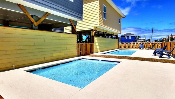 A residential area with a swimming pool and a covered patio area. - Sweet Home La Cabana Patio BBQ Community Pool (Port Aransas)