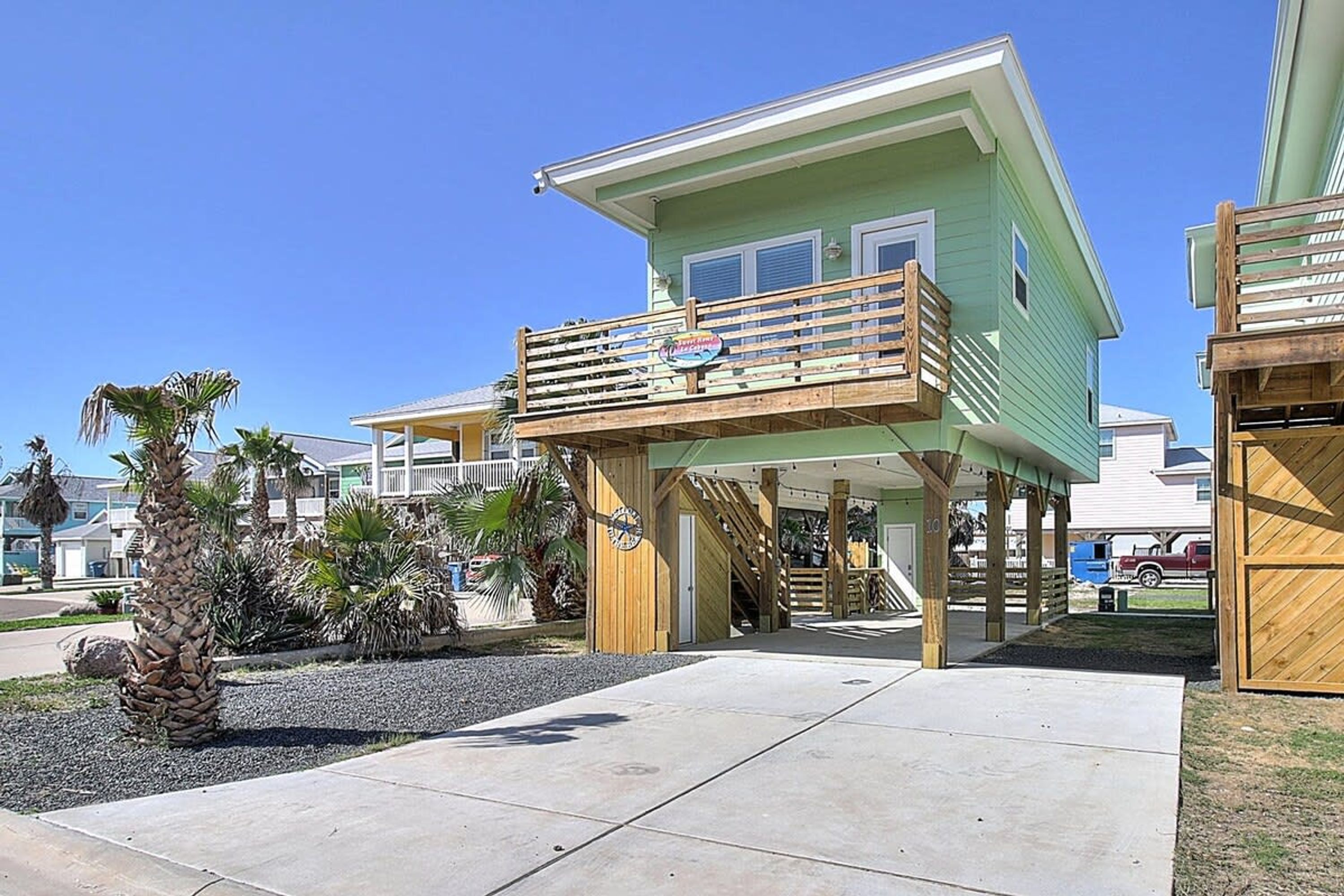 A beachfront property with a two-story building, a wooden deck, and a covered outdoor area.