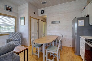 Une cuisine de taille réduite comprenant une table et des chaises, un canapé et un réfrigérateur.