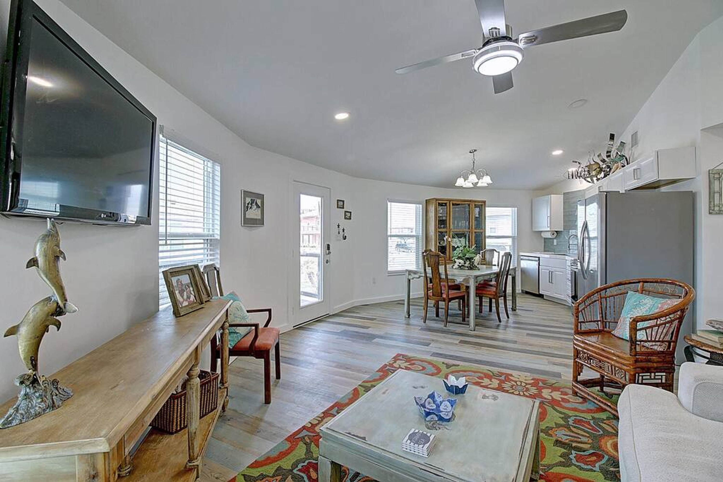 A spacious living area with a television, dining table, and chairs.