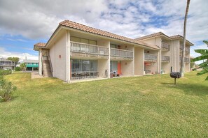 Un edificio de dos pisos con un balcón en la planta baja y un patio cubierto.