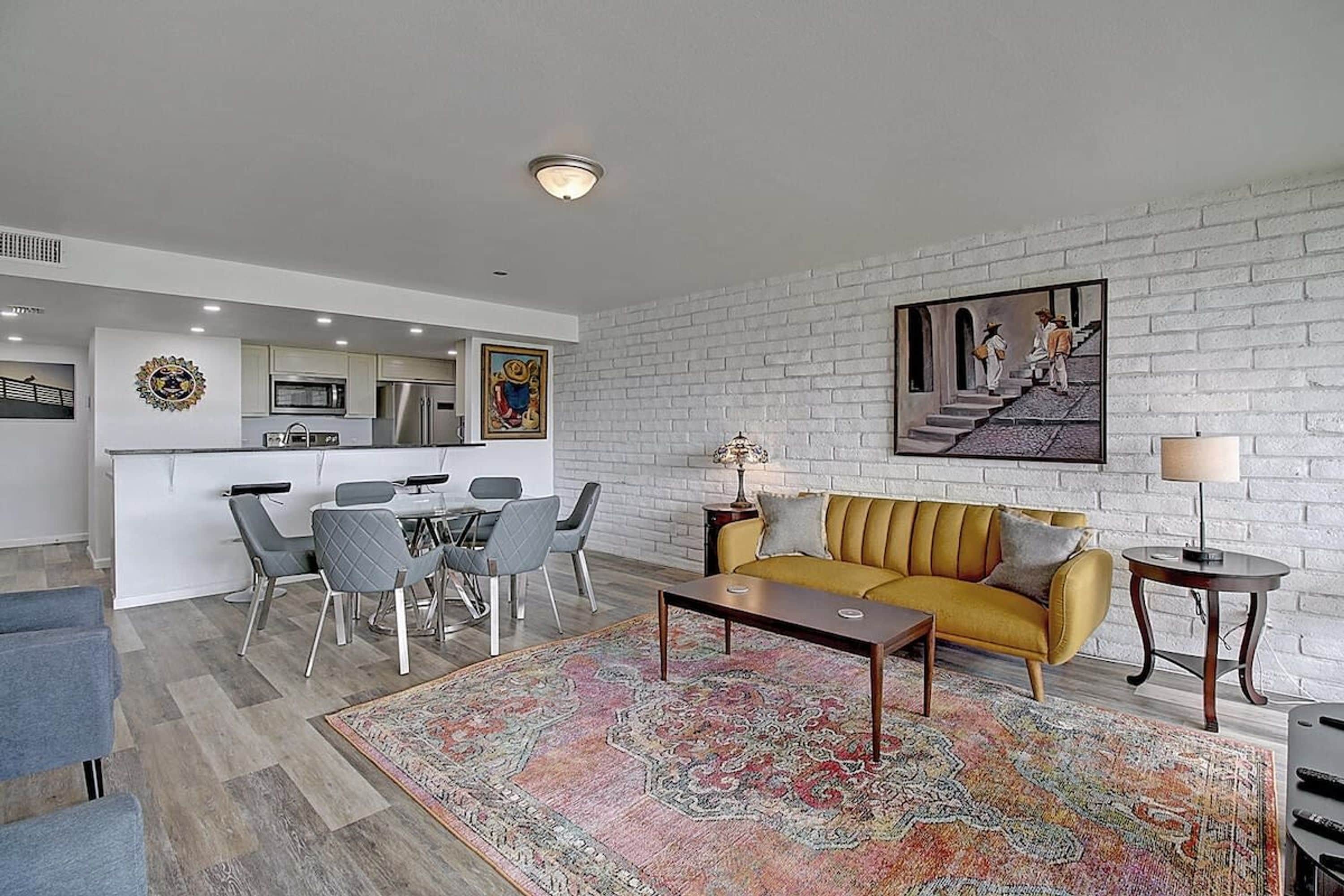 A modern living room with a sofa, a coffee table, and a rug.