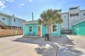 A residential area with houses, a palm tree, and a barbecue grill. - Blue Wave Community Pool Family Friendly Sleeps 10 (Port Aransas)