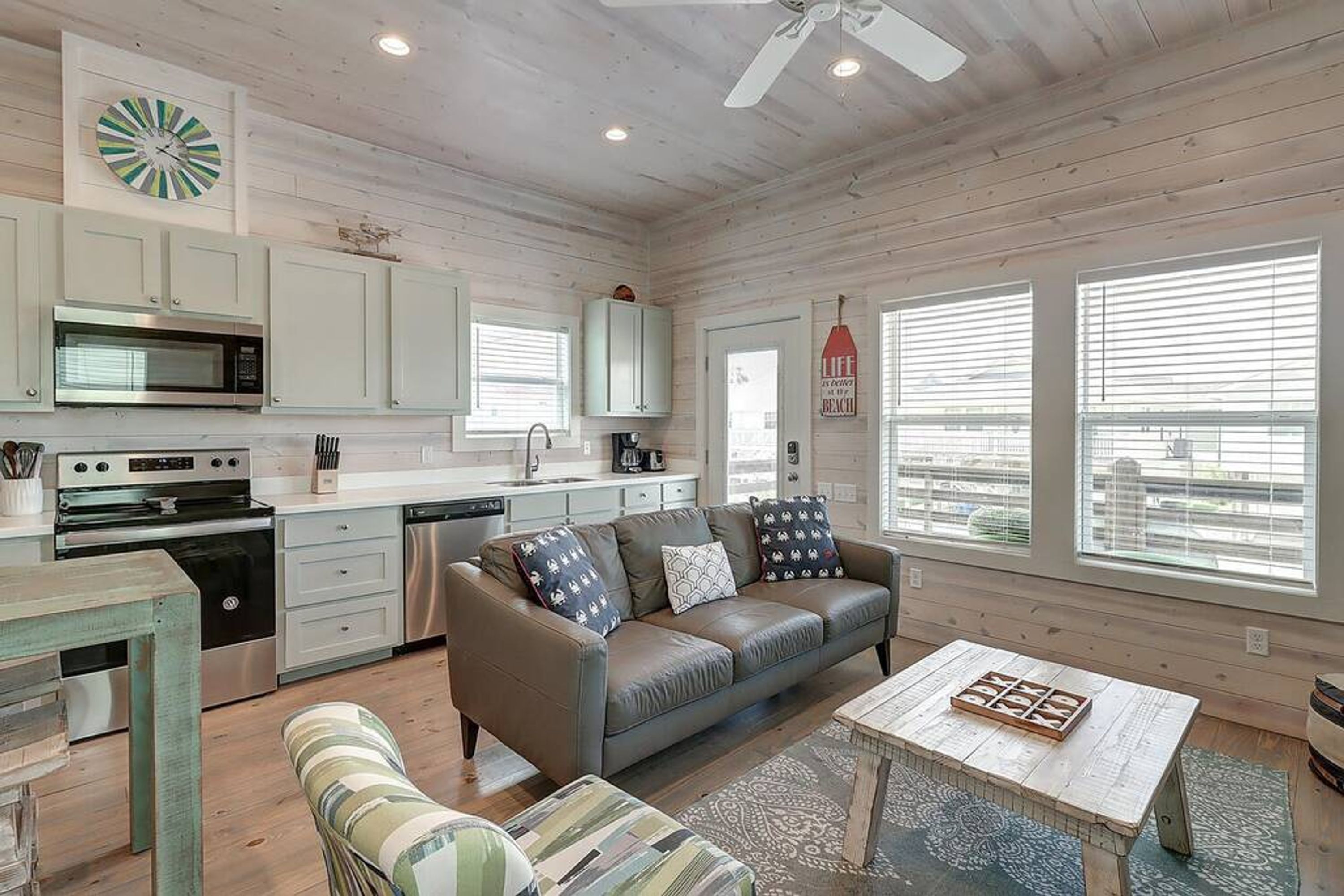 Un intérieur de chalet chaleureux et accueillant, comprenant un coin cuisine, un canapé et un espace repas.