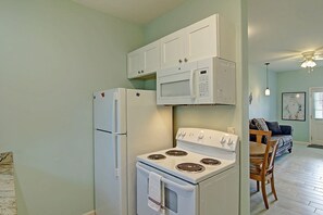 Eine kleine Küche mit Kühlschrank, Mikrowelle und Herd.
