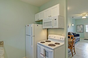 Cocina compacta con refrigerador, microondas y estufa.