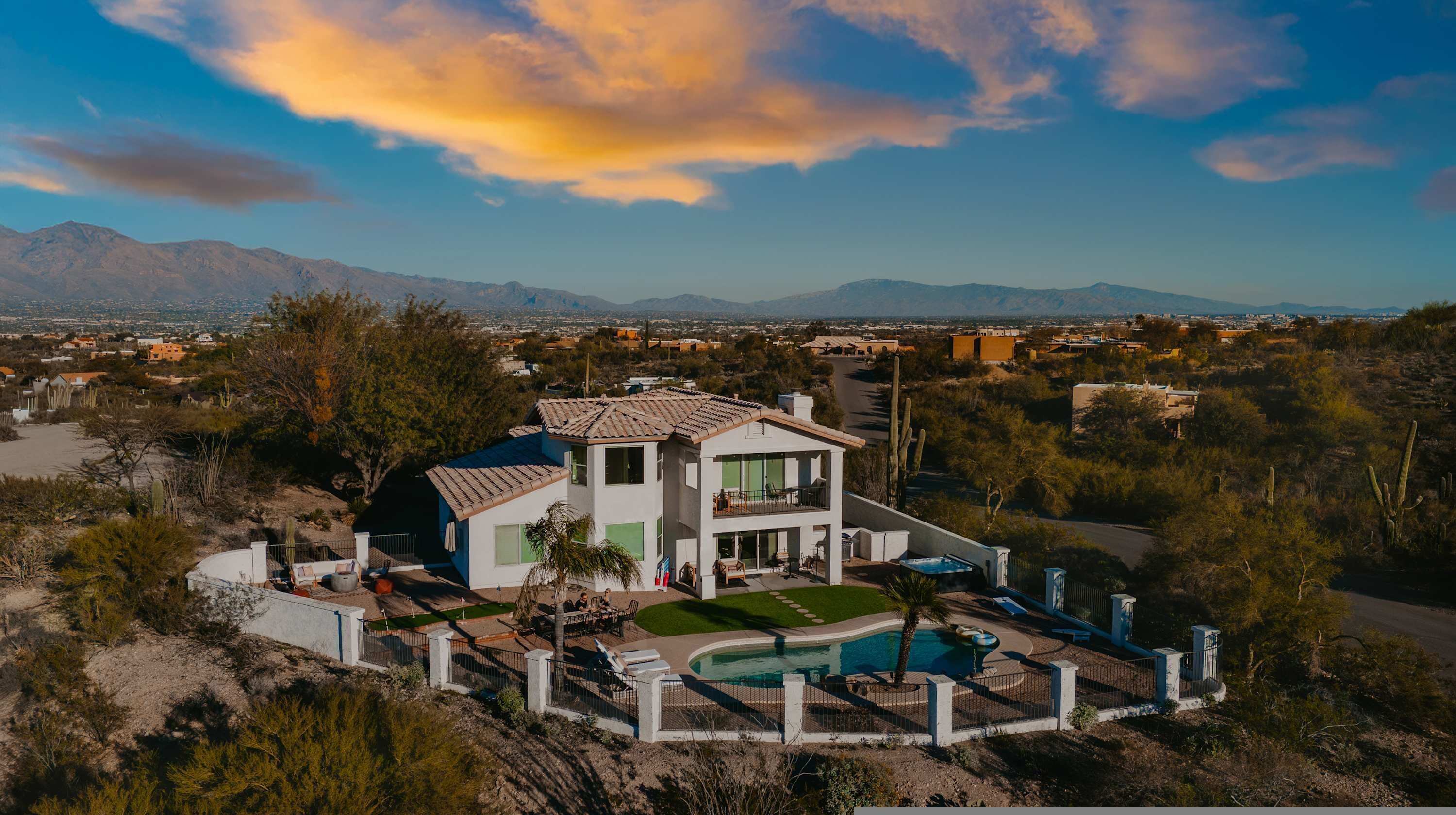 Una casa de dos pisos con piscina y vistas del paisaje circundante.