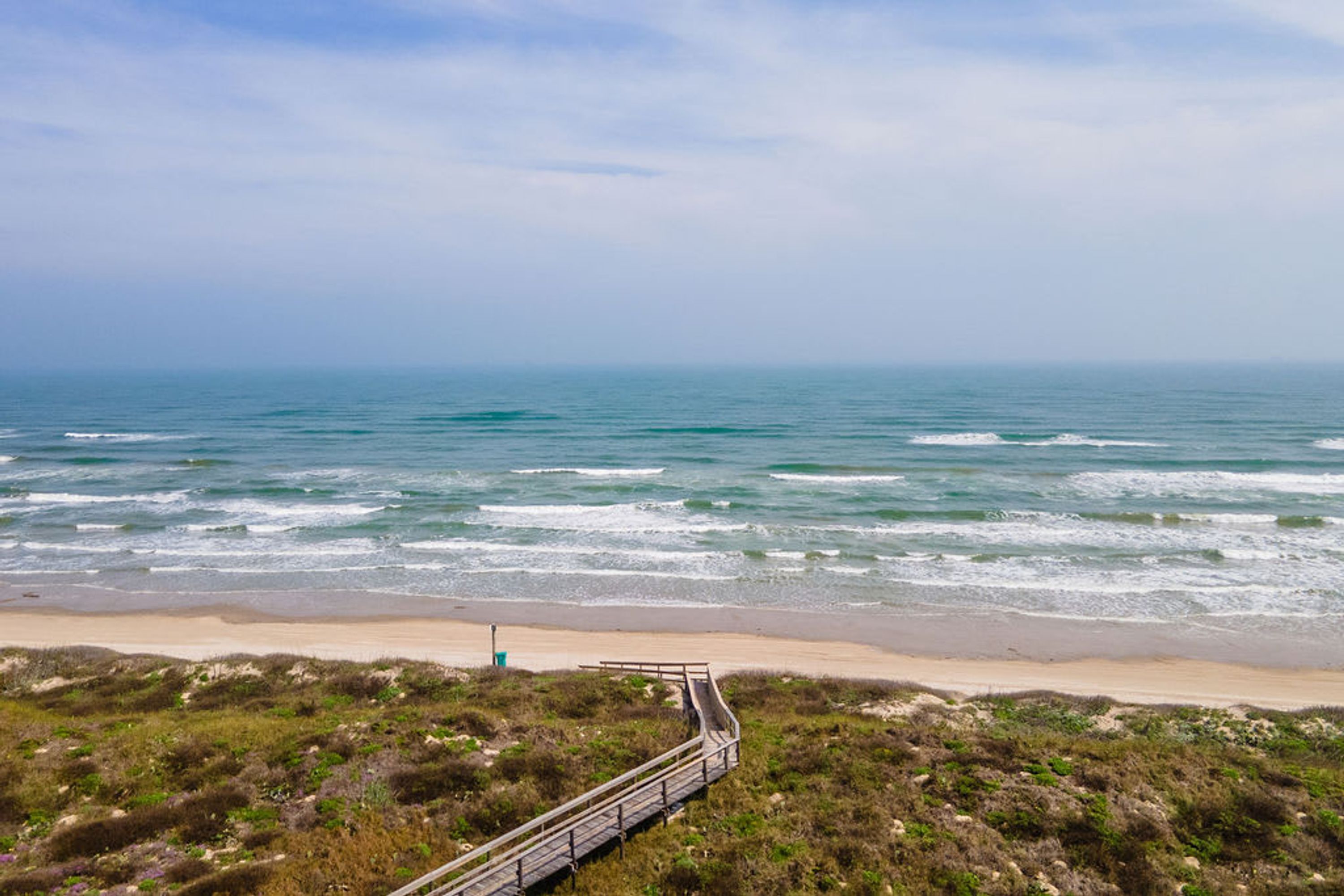 Un camino costero que lleva a la playa, con vista despejada al océano.