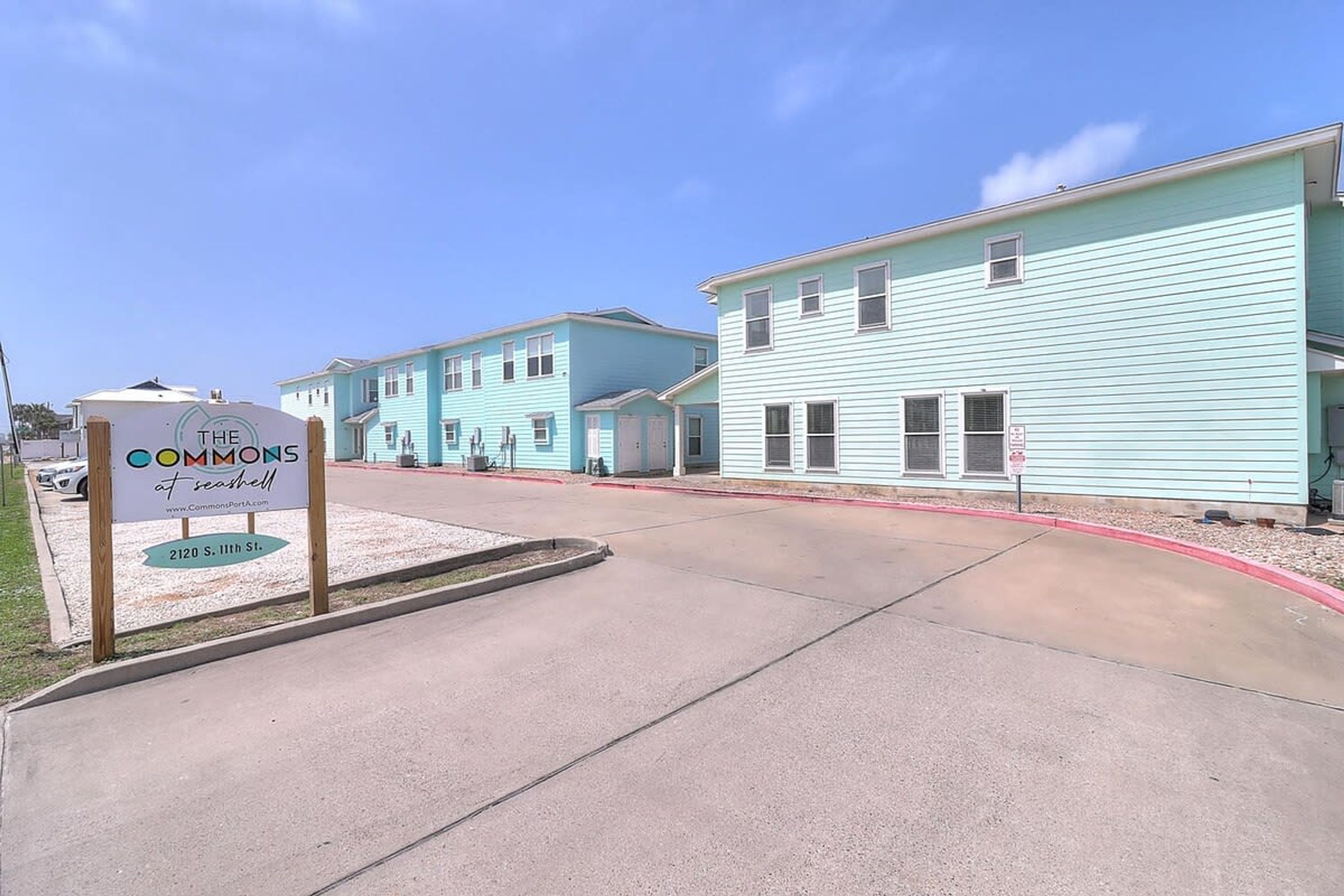 A row of light blue buildings with a sign indicating 'The Commons at Seashore.'