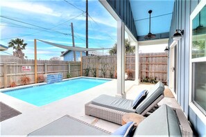 A backyard with a swimming pool, outdoor furniture, and a wooden fence. - La Puerta Rosada Private Pool Prime Location (Port Aransas)