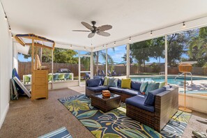 A covered outdoor seating area with a pool, wicker furniture, and a ceiling fan. - 5 Min to Beach Heated Pool Golf Sleeps 12 (Seminole)