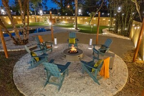 A circular outdoor seating area with a fire pit, surrounded by chairs and a pool. - 5 Min to Beach Heated Pool Golf Sleeps 12 (Seminole)