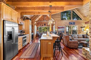 Ein geräumiges Blockhaus-Interieur mit Küche, Essbereich und Wohnzimmer.