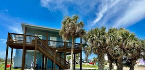 A two-story building with a wooden staircase and a balcony. - Mustang Island Beach Side Sanctuary Game Room (Port Aransas)