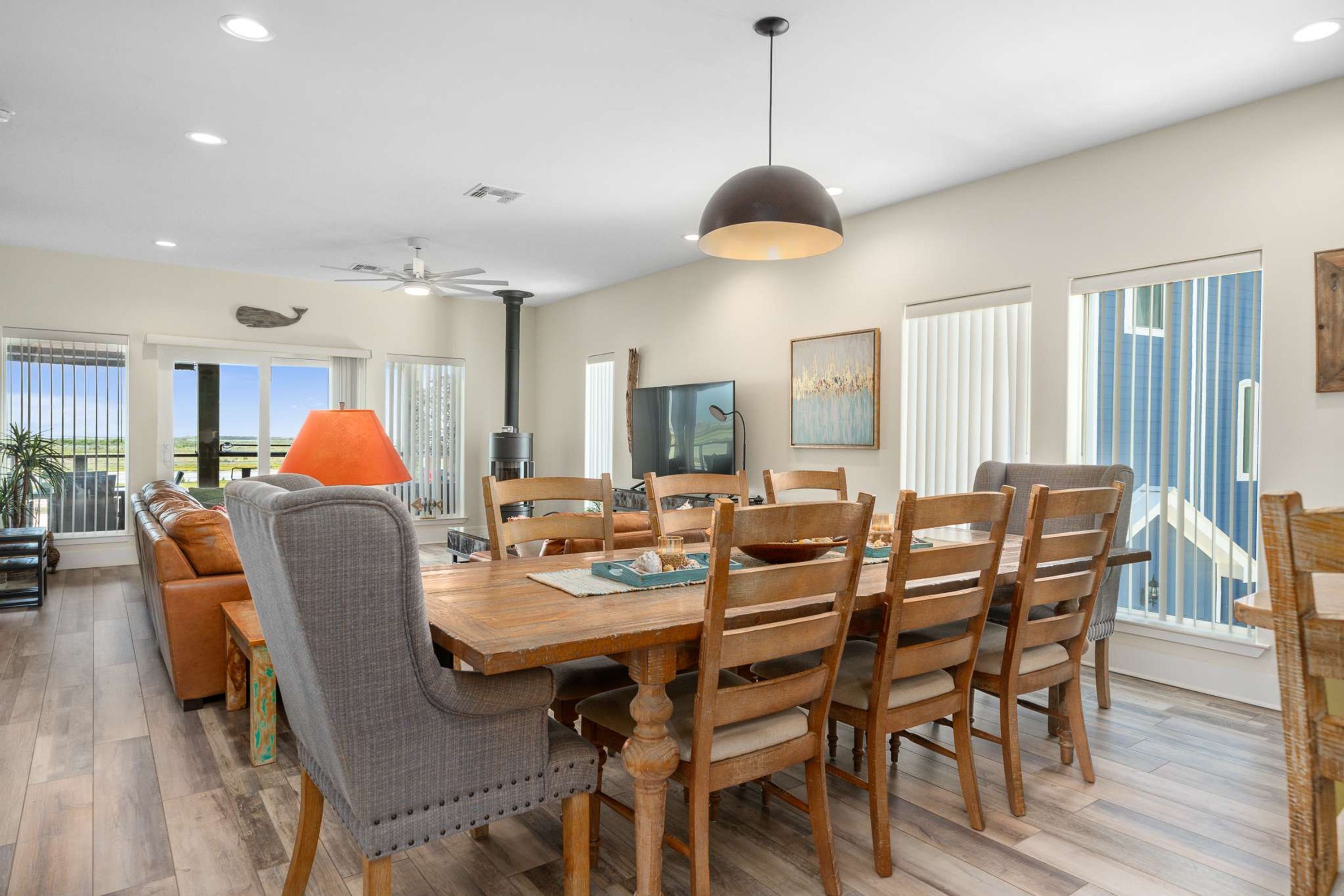 A dining area with a wooden table, chairs, and a ceiling fan.