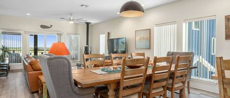 A dining area with a wooden table, chairs, and a ceiling fan.