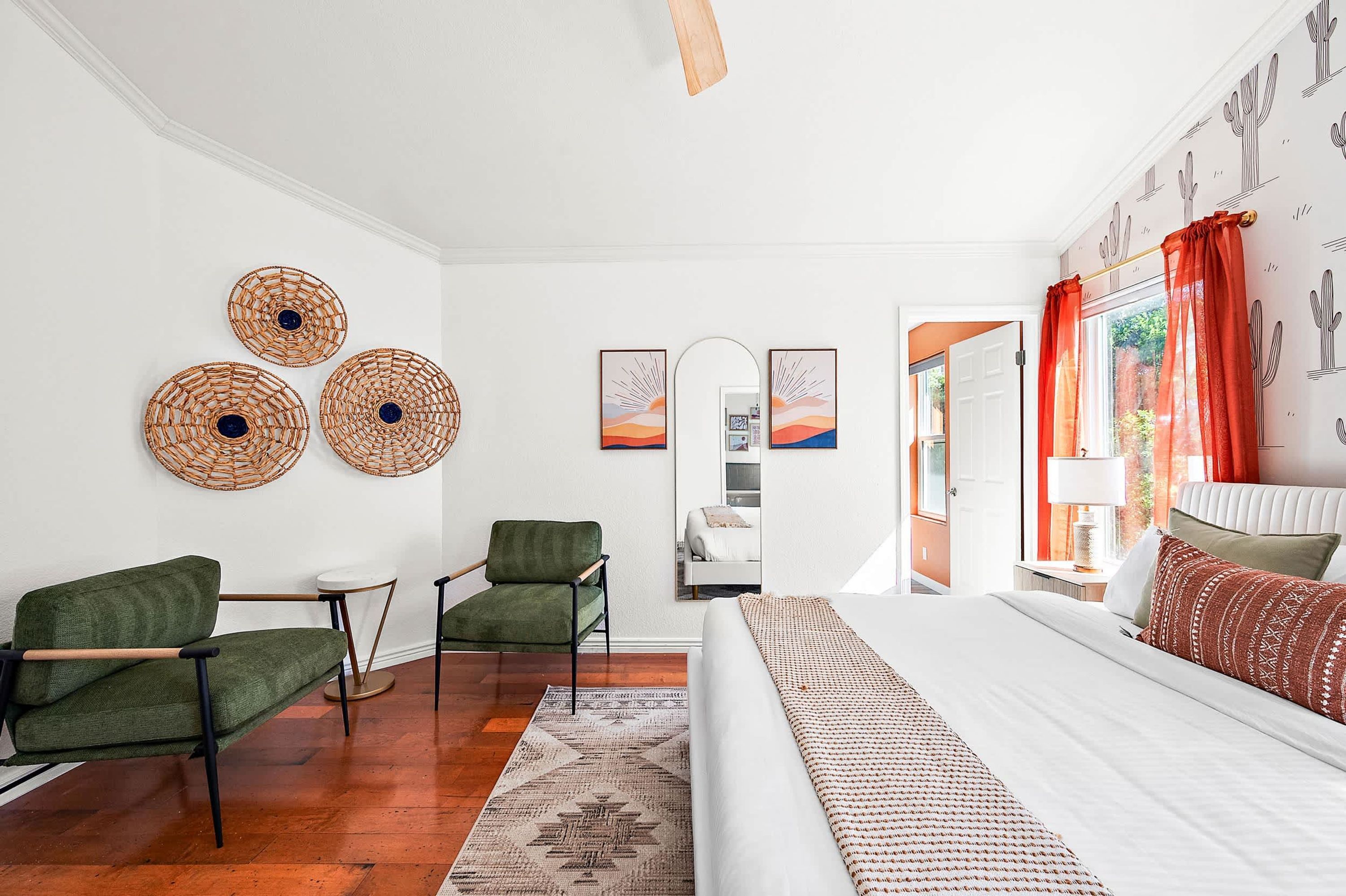A bedroom with a bed, two chairs, a small table, and a rug.