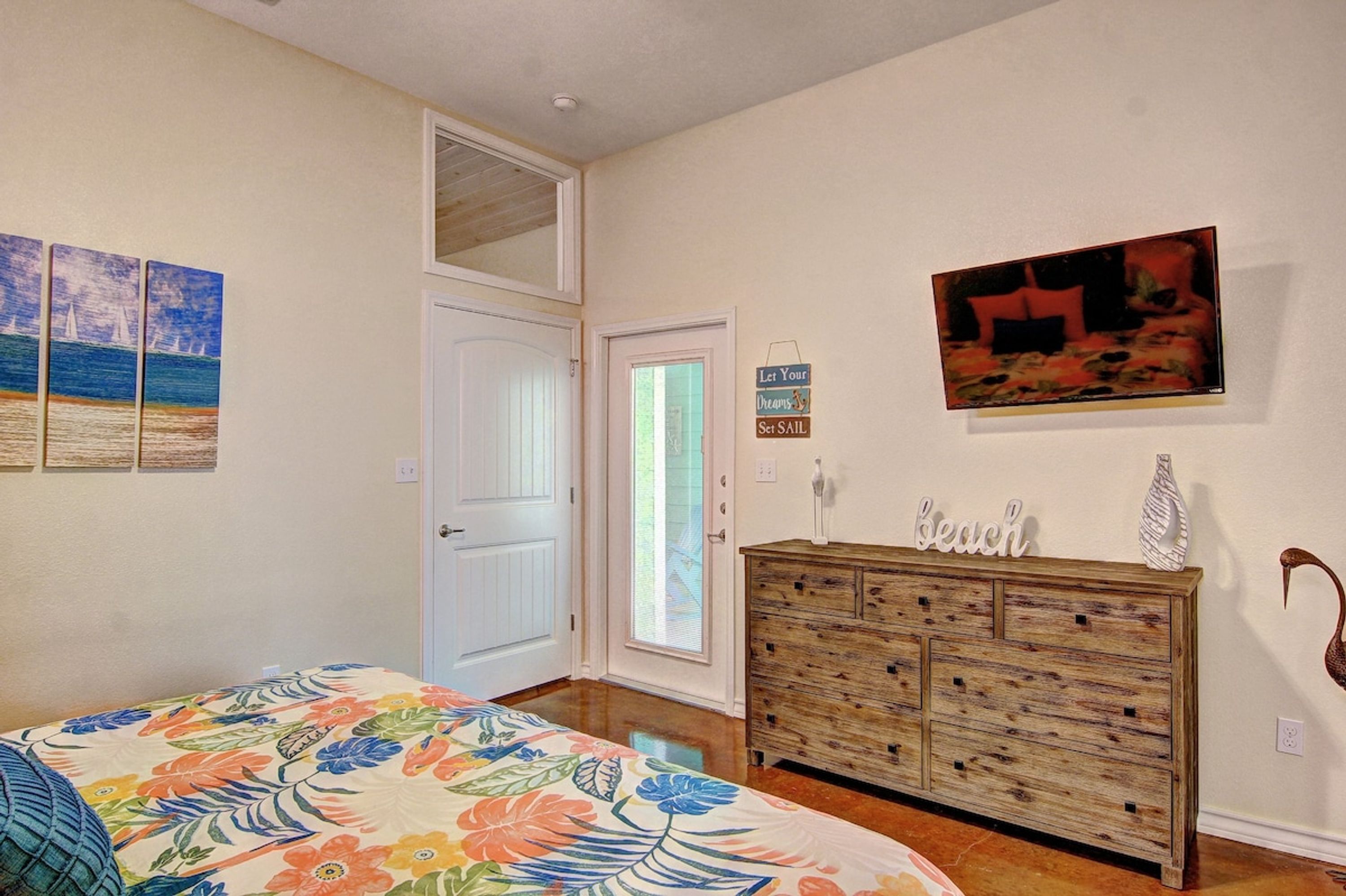 Une chambre à coucher avec un lit, une commode, une porte et des éléments décoratifs sur les murs.