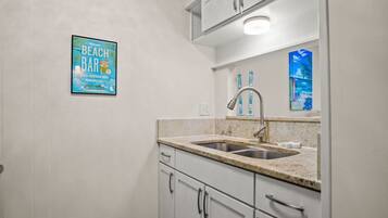 A kitchen with a sink, cabinets, and a countertop.