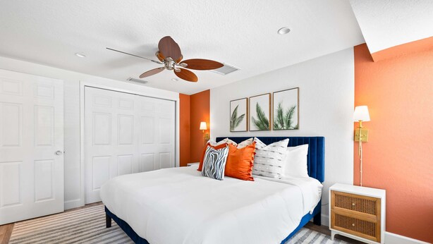 A hotel room with a bed, a ceiling fan, a wall-mounted air conditioning unit, and a door. - Minutes to Anna Maria Island Pool Mini Golf (Bradenton)