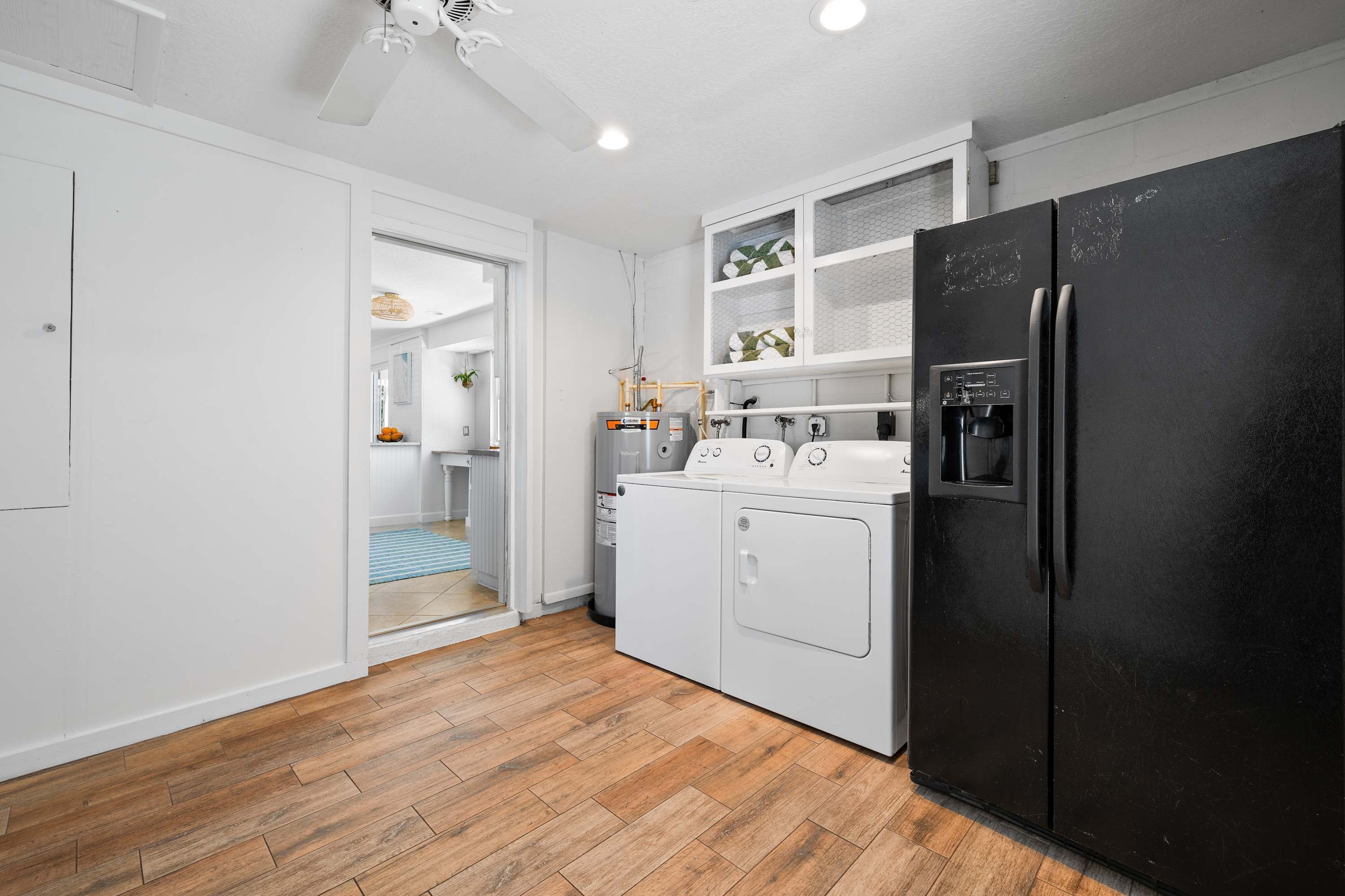 Una cocina compacta con un refrigerador negro, una estufa y una lavadora.
