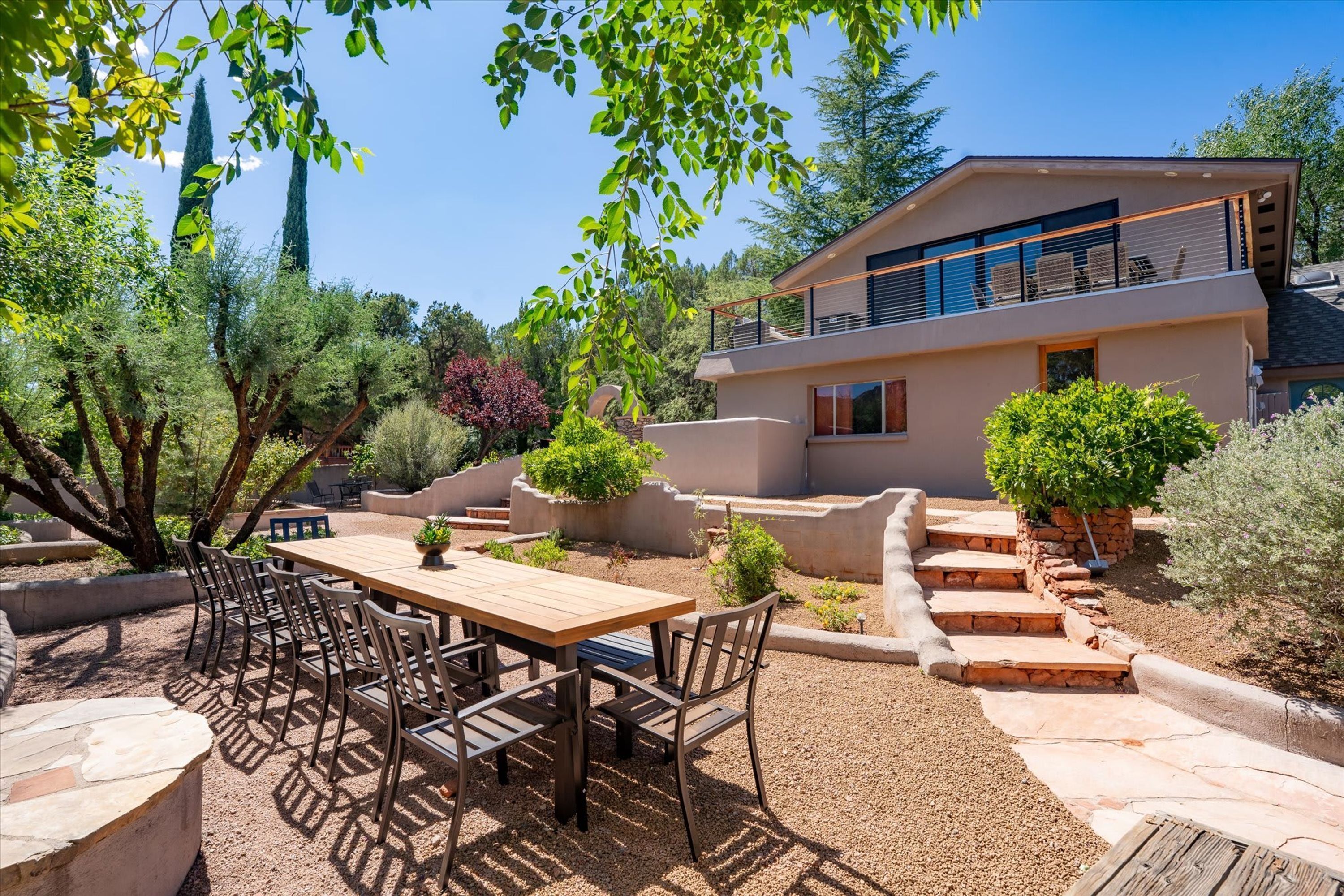 A modern house with a patio area, outdoor seating, and a garden.